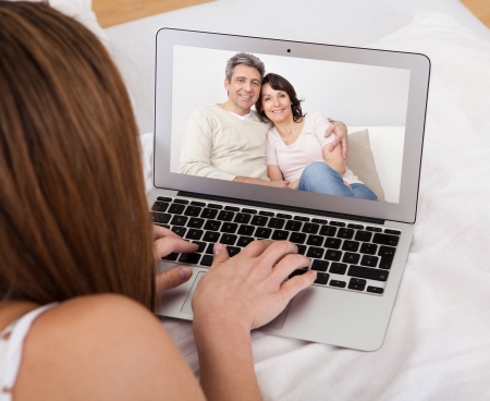  portrait of young woman video chatting with parents homesickness studying abroad