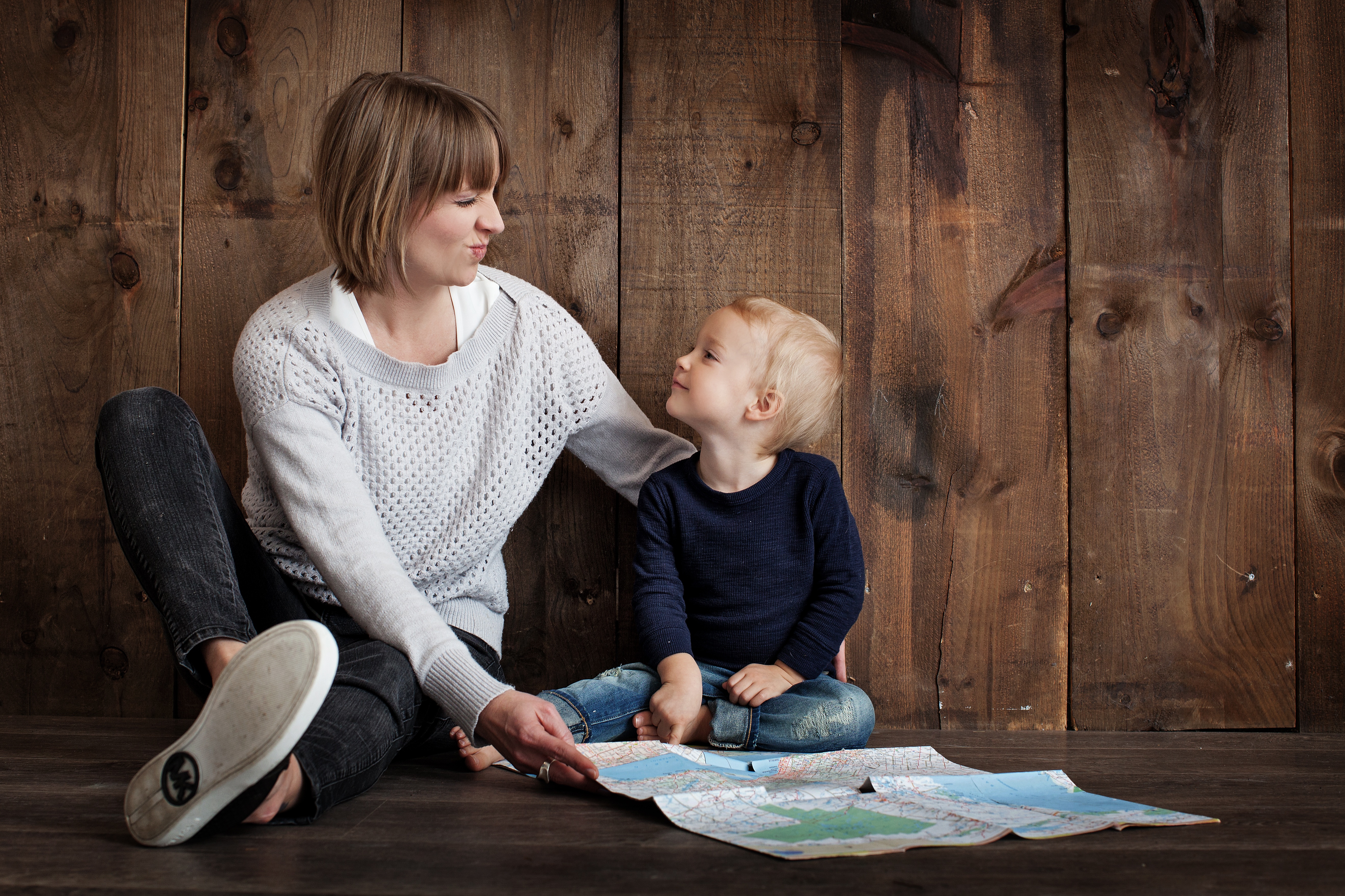 pell grant for single mothers mother sitting with son against wooden backdrop