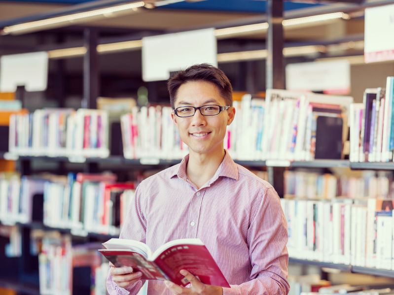 happy male asian student holding books at the library concept for Homework answers website, How to get answers for homework