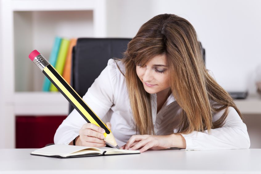 businesswoman taking some notes on her notepad with a giant pencil concept for Perfect Personal Statement